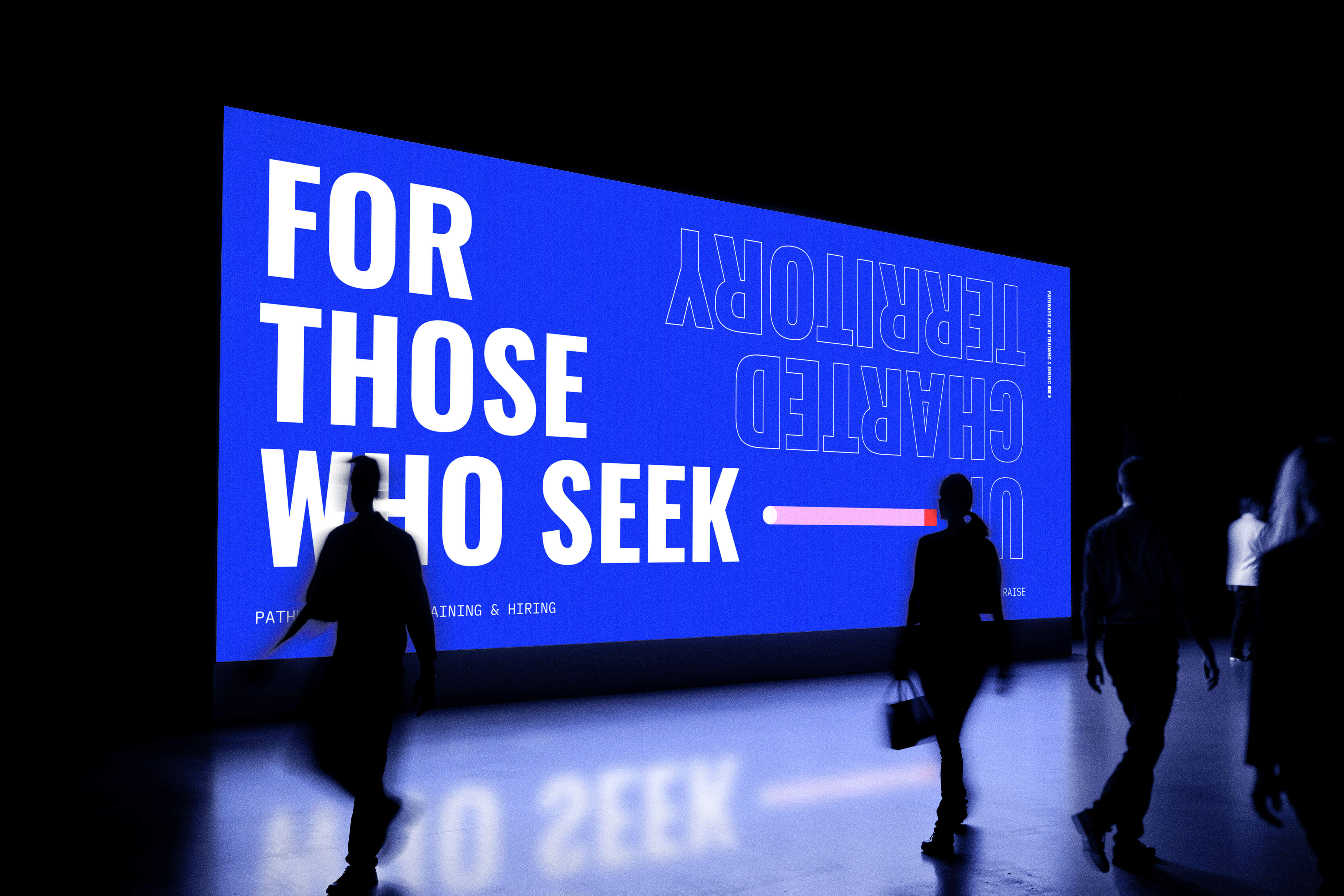 Blue digital billboard reads "For those who see uncharted territory," people walking by