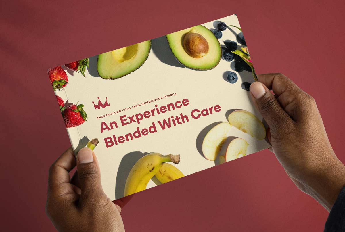 Hands holding a copy of the Smoothie King ideal state experience playbook