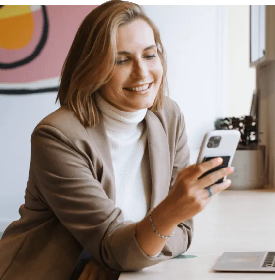 woman checking smartphone at desk