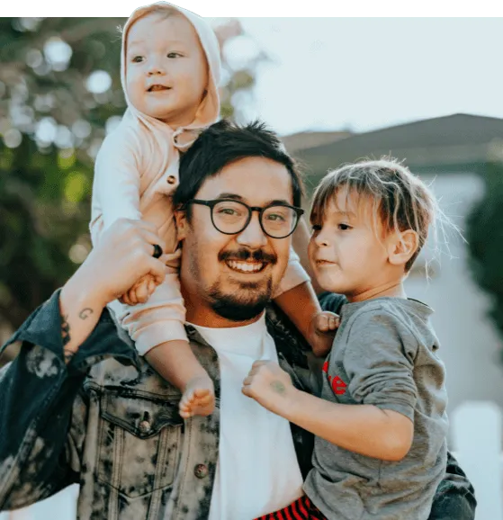 dad holding one child with another on his shoulders