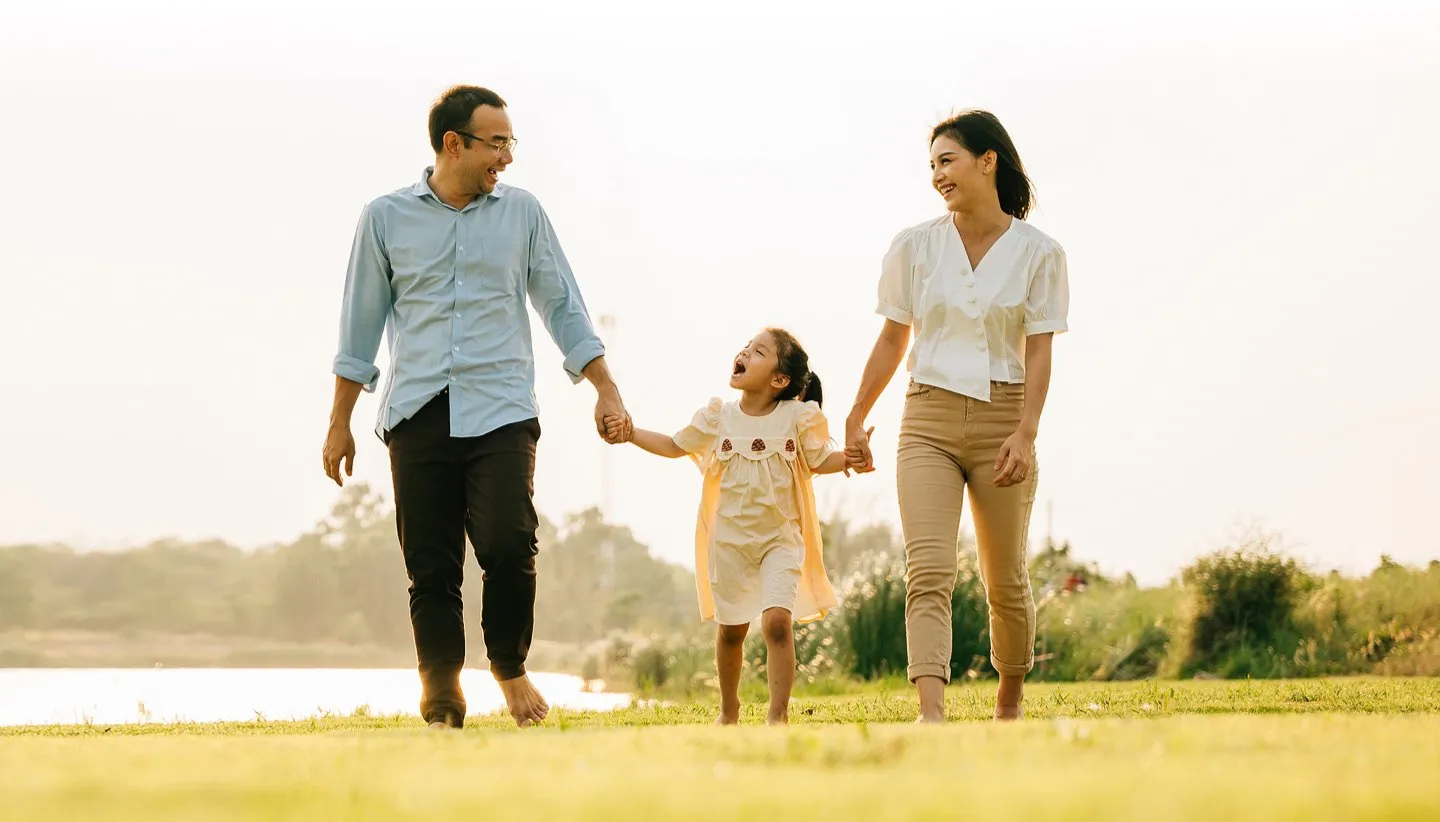 husband and wife walking with daughter outdoors