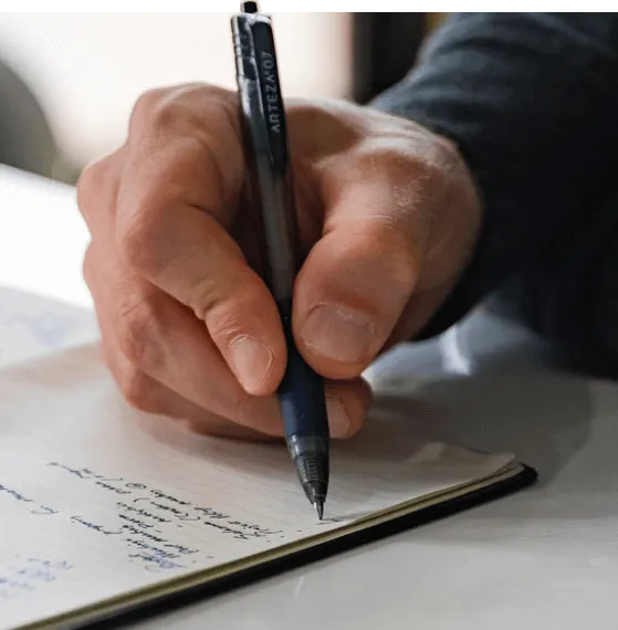 person writing in notebook