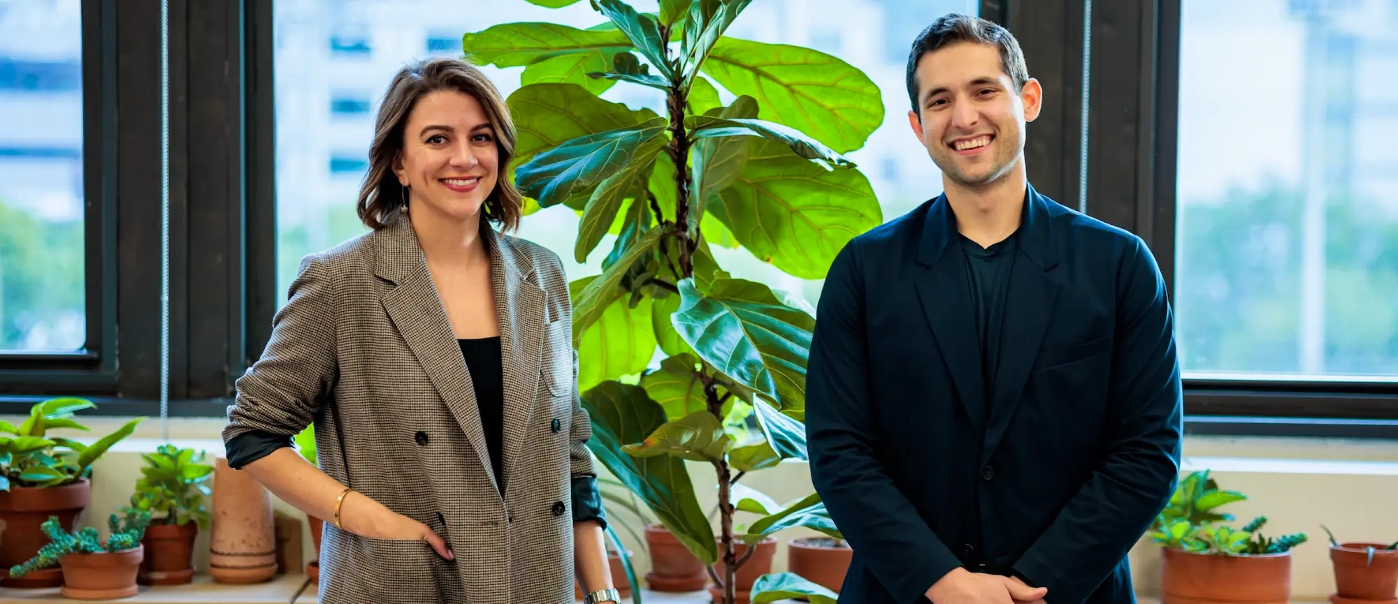 Shara Ticku and David Heller standing next to a plant