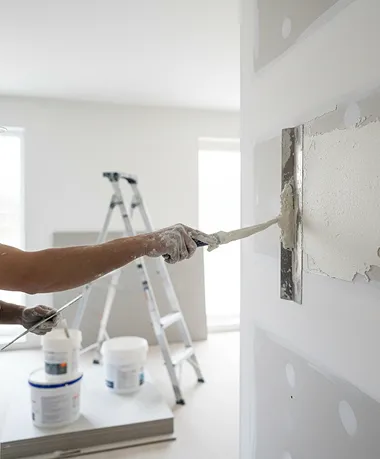 Close-up of contractor applying drywall compound during remodeling