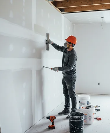 Contractor remodeling interior space by finishing drywall seams