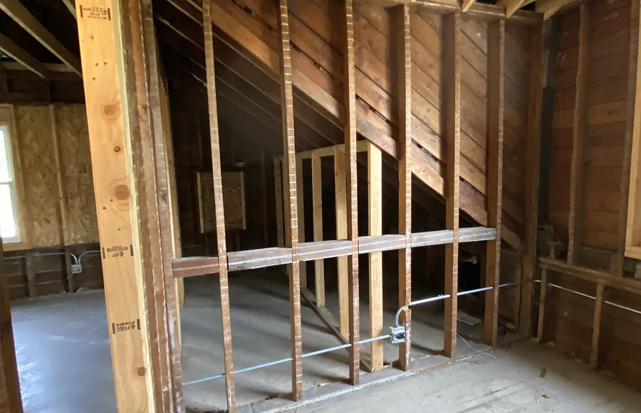 Exposed knee wall framing in an unfinished attic before insulation installation