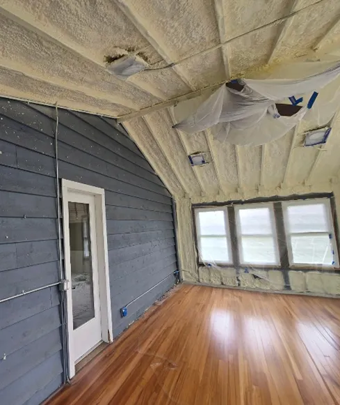 Closed-cell spray foam insulation applied in a residential Chicago attic, sealing the roof deck for advanced temperature control