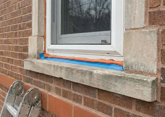 Exterior window gaps sealed on a brick home to prevent rodents and pests