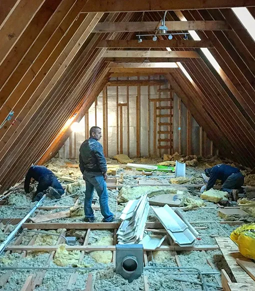 Crew upgrading bungalow attic insulation to cellulose for better winter and summer temperature control