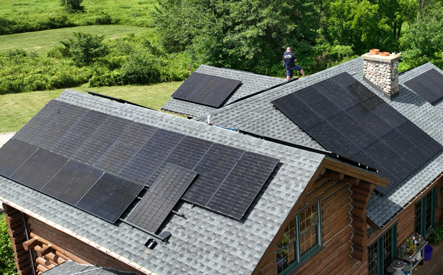 Residential roof with solar panels installed across multiple roof sections