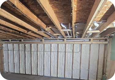 Basement perimeter wall fully insulated with white spray foam between studs