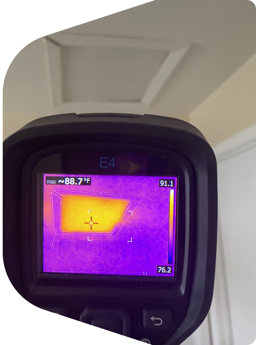 Blown-in attic insulation with depth ruler and insulated HVAC duct under roof rafters