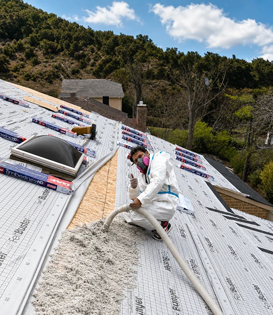 Technician installing roof insulation during a roof replacement