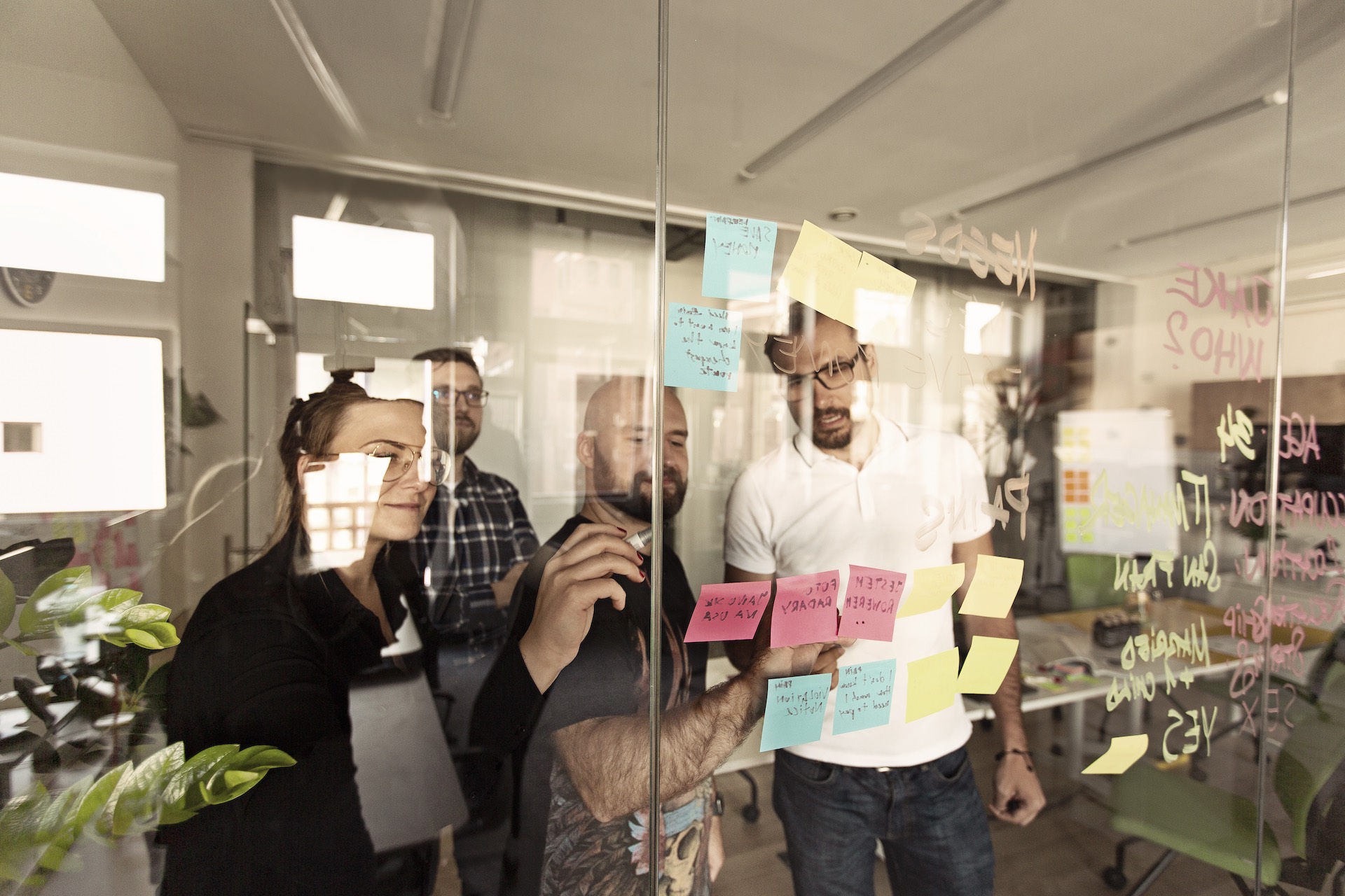 people in front of a glass wall with notes