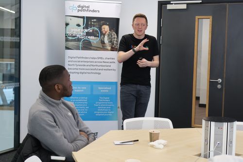A woman and a man sitting and having a discussion about technology