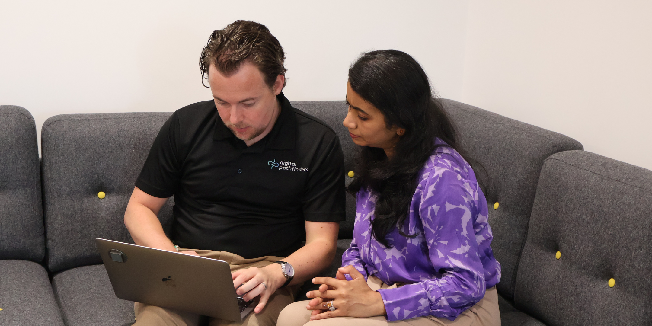 A woman and a man sitting and having a discussion about technology