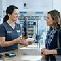 women talking to a pharmacist in a pharmacy setting