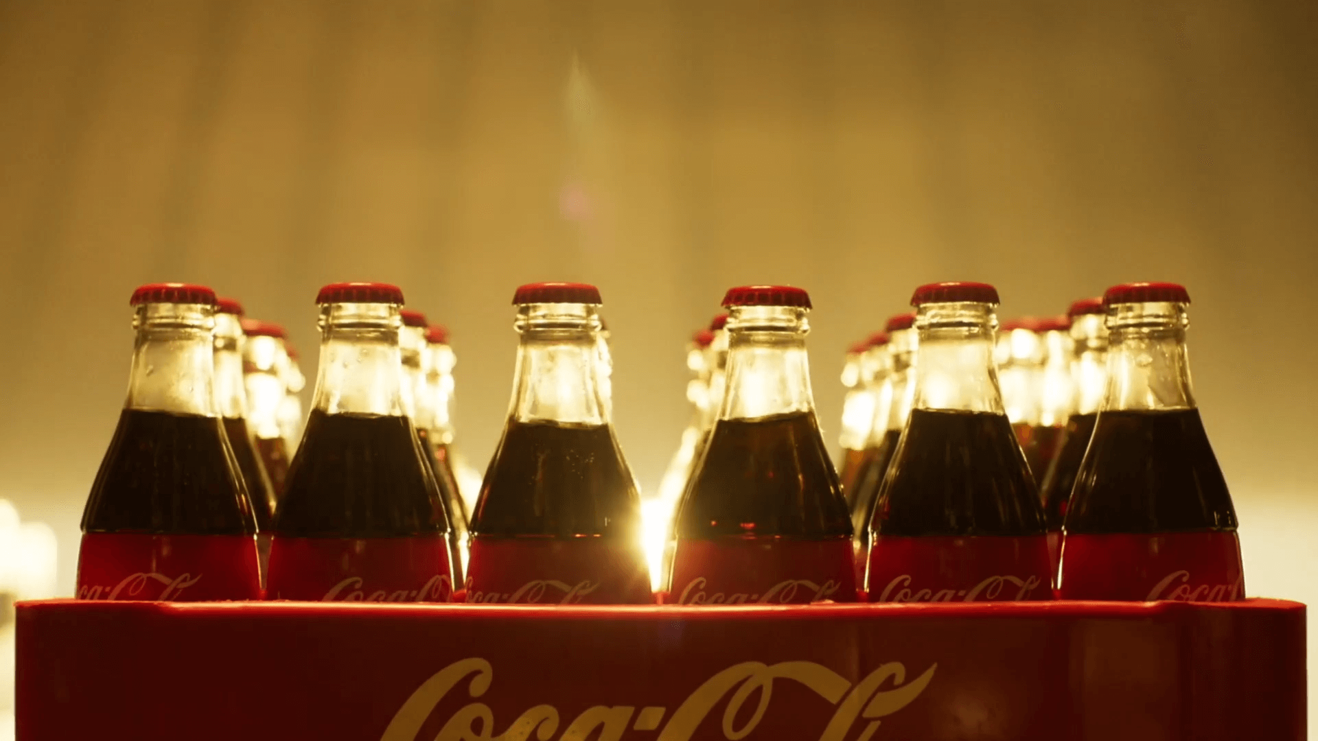 A backlit crate of glass Coca Cola bottles