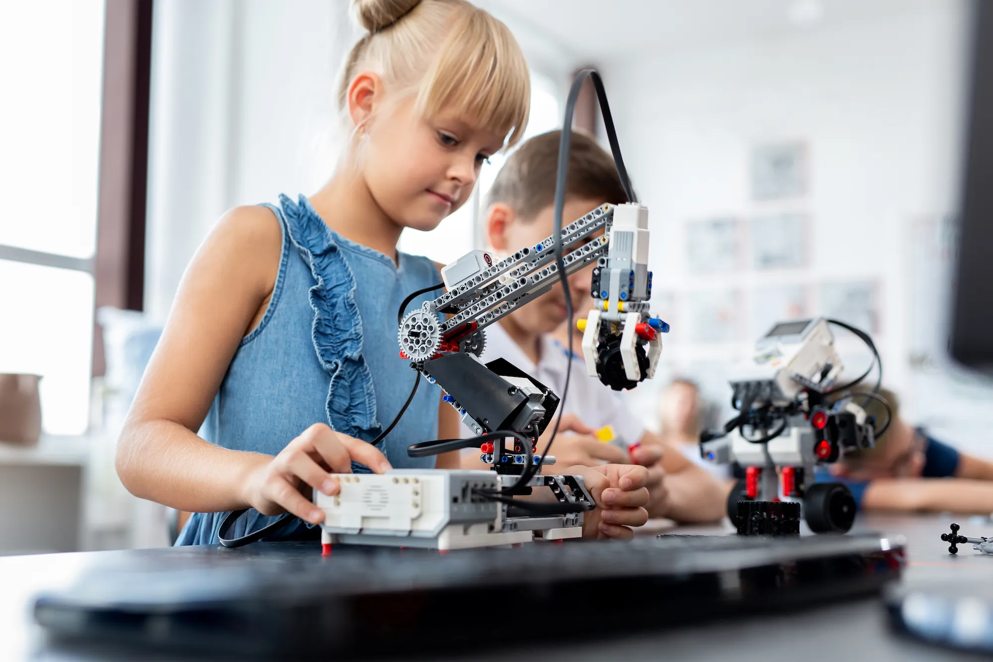 Kinder, die in der Schule mit einem kleinen Roboter arbeiten.