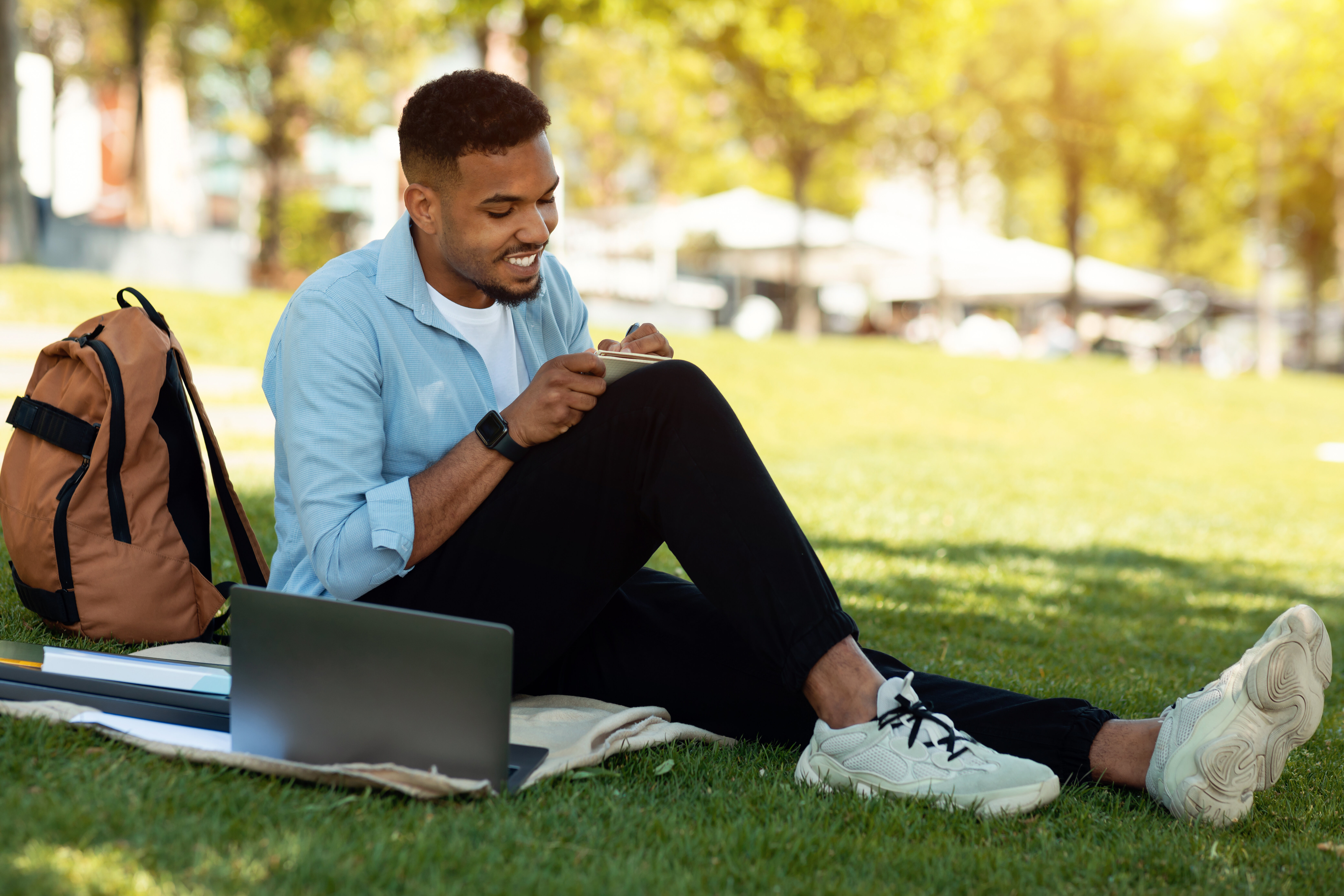 student sitting outside while taking notes