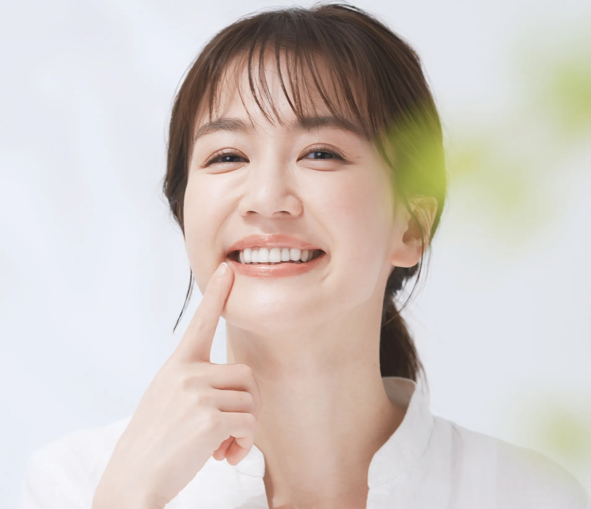 Woman pointing at teeth, smiling