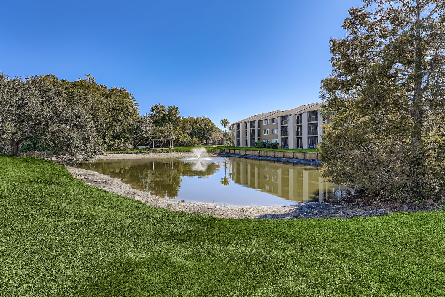lake with fountain and view of exterior
