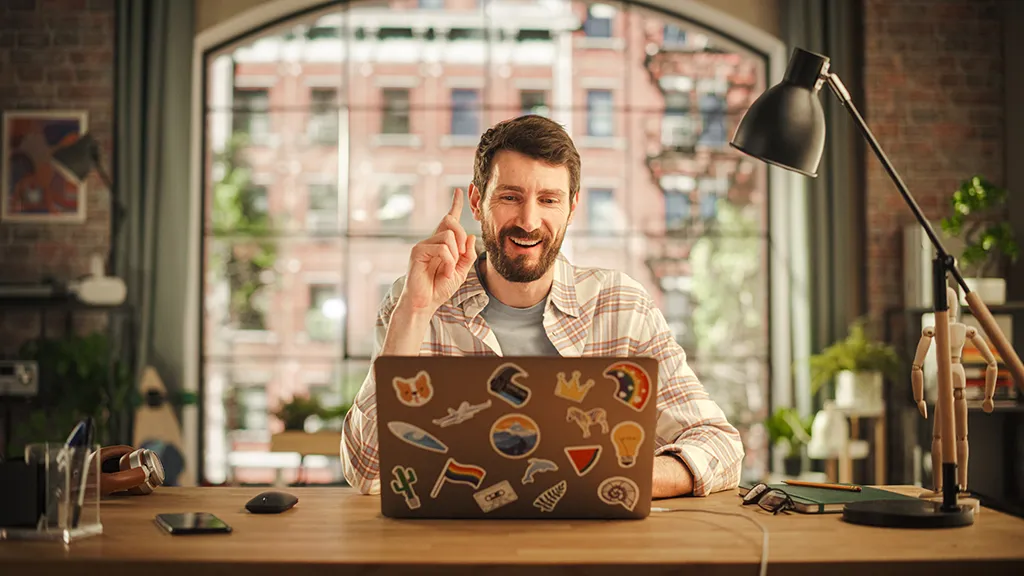 Happy male writer working on a laptop