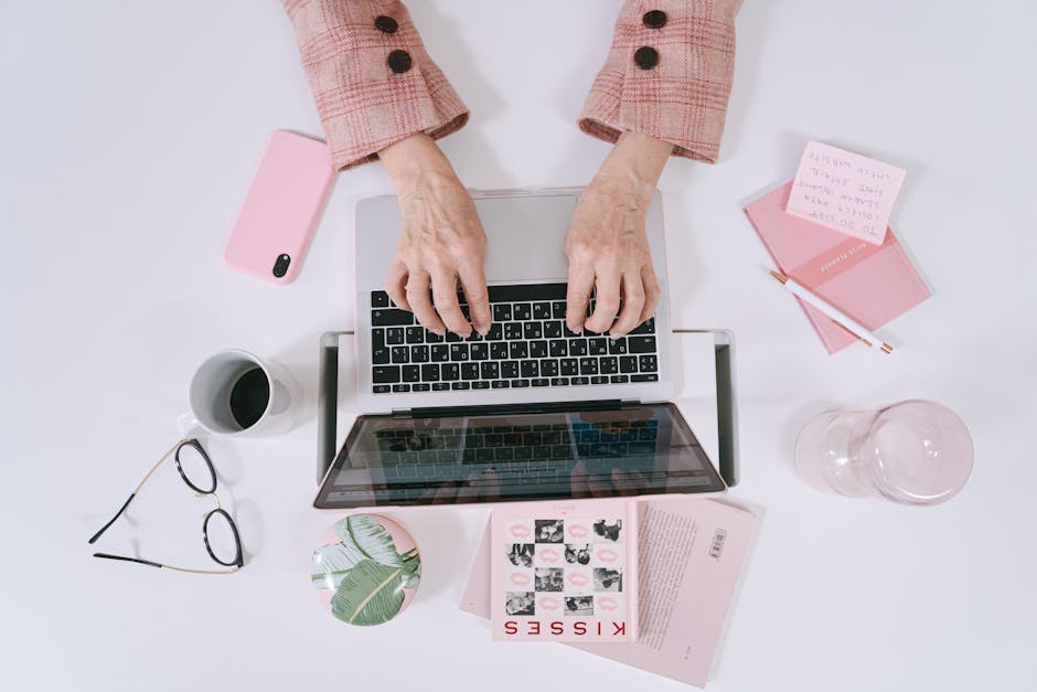 A modern workspace featuring a person managing calls on their cell phone, with a laptop and planner visible, symbolizing productivity.