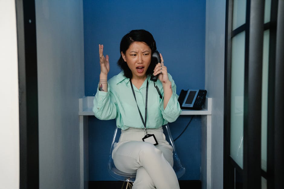 A person frustrated while on a call, surrounded by technology and various devices, depicting the confusion of call drops.