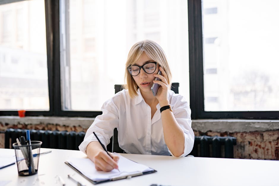 A business professional at a desk, focused on their phone while disabling call forwarding settings, surrounded by notes and communication tools.