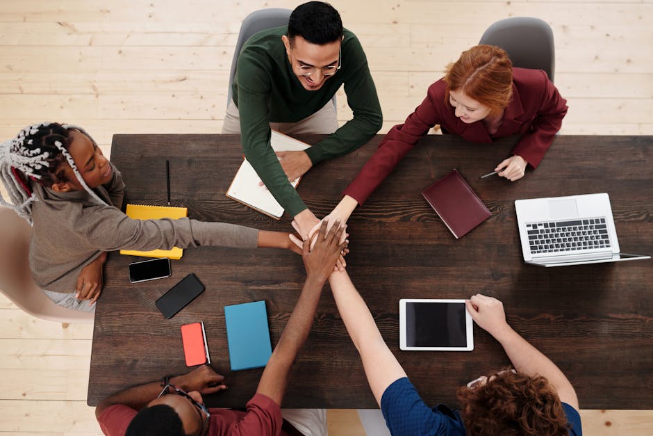 A dynamic office setting showcasing collaborative technology in action, with team members engaging with a CRM interface on their devices.