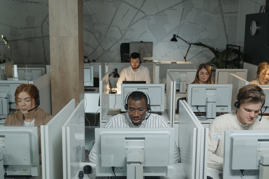 A dynamic office scene showcasing a team efficiently communicating via modern technology, highlighting the importance of call forwarding systems.