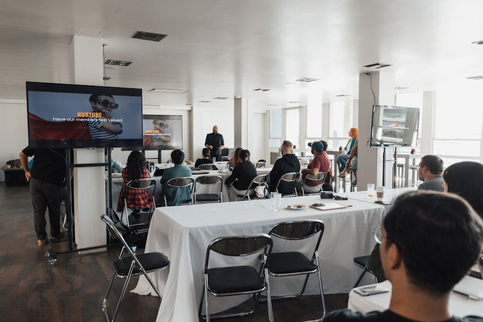 A diverse group of business professionals engaged in a discussion over a conference call, with visual representations of call recordings displayed on a screen.