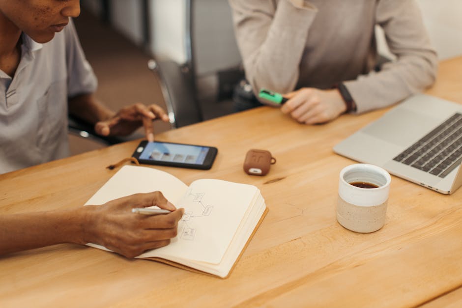 A close-up of a smartphone with a voicemail icon highlighted, surrounded by notes and a cup of coffee to symbolize business communication.