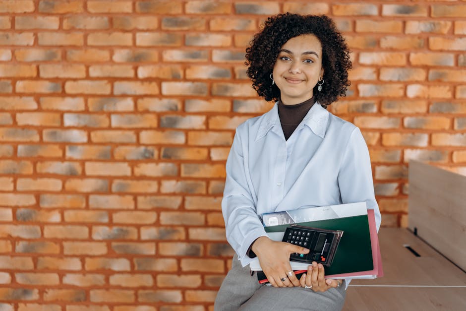 A confident professional smiling while answering a phone in a warm office environment