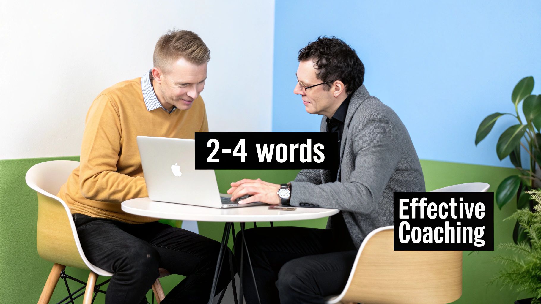 Two business professionals collaborating on laptop discussing effective coaching techniques in modern office setting