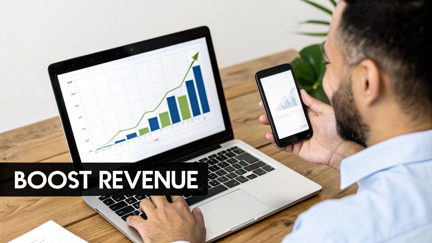 A man monitors revenue growth graphs on a laptop and smartphone, actively managing business progress.