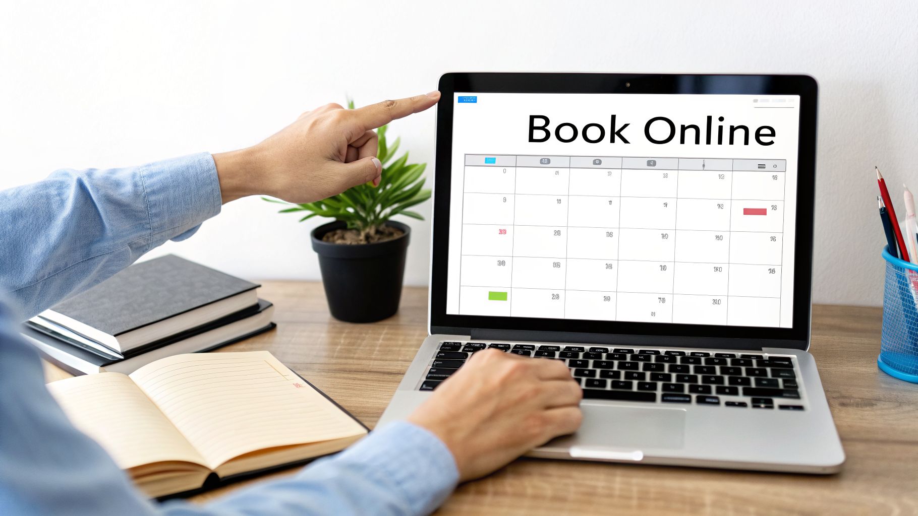A person points at a laptop screen displaying 'Book Online' and a calendar for online scheduling.