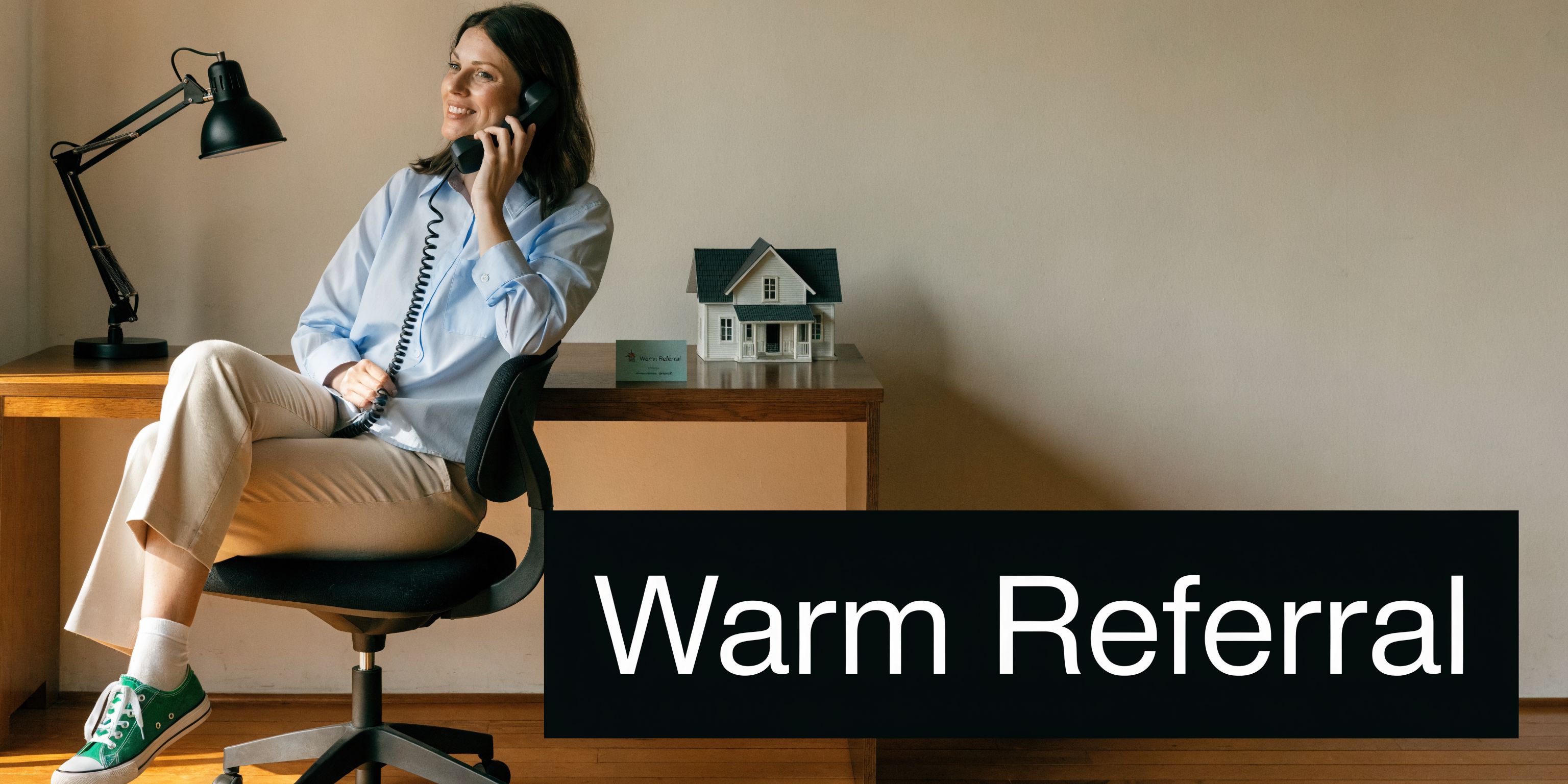 A professional woman in a bright office sitting at a desk and speaking on the telephone.