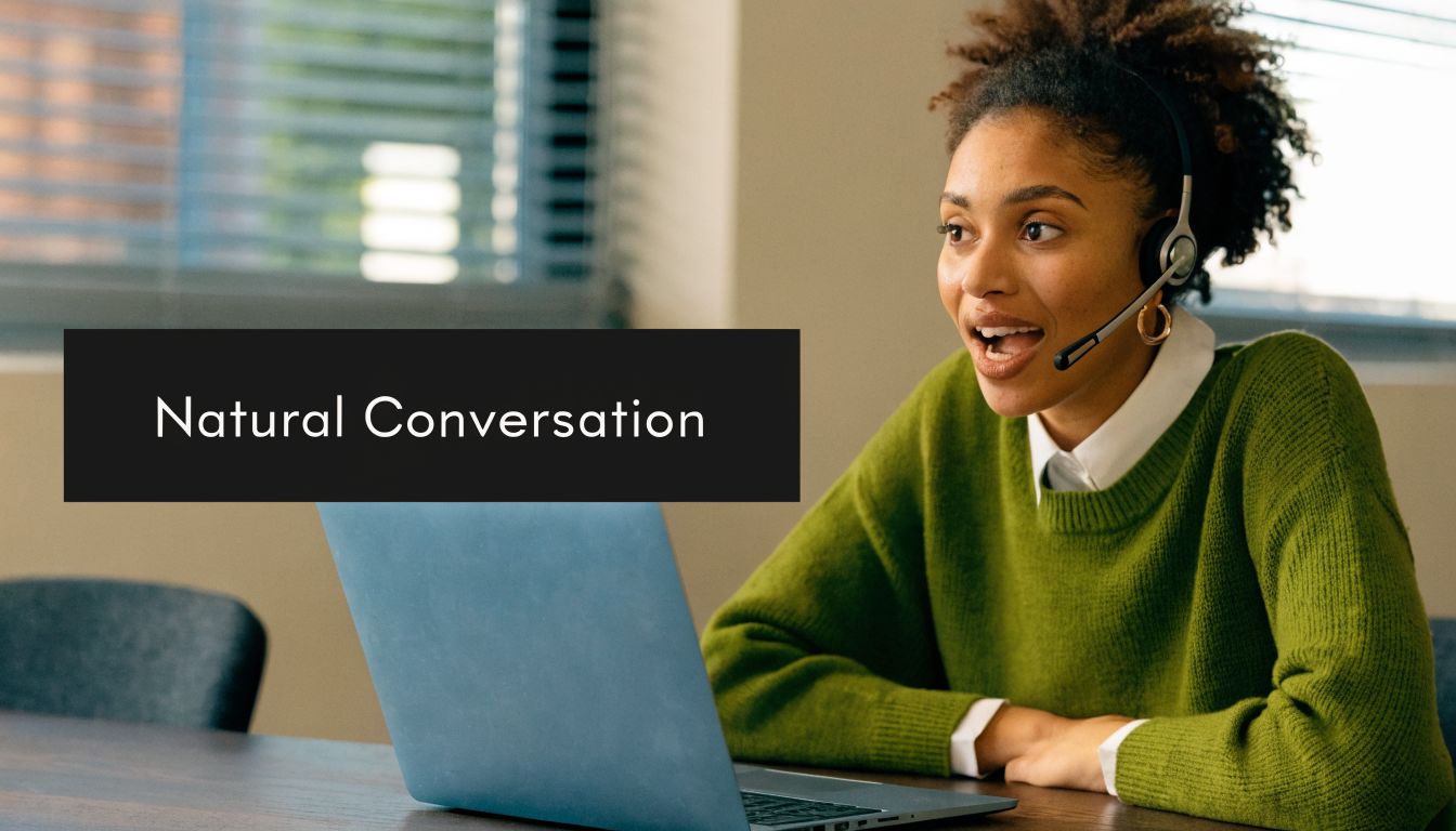 A woman wearing a headset while sitting in front of a laptop, engaging in a natural conversation.