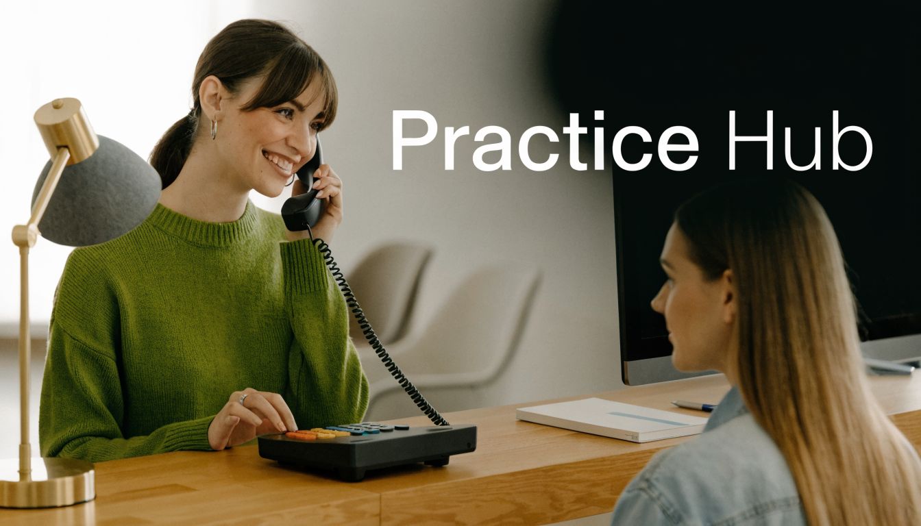 A friendly dental receptionist in a green sweater talking on the phone at a modern office desk.