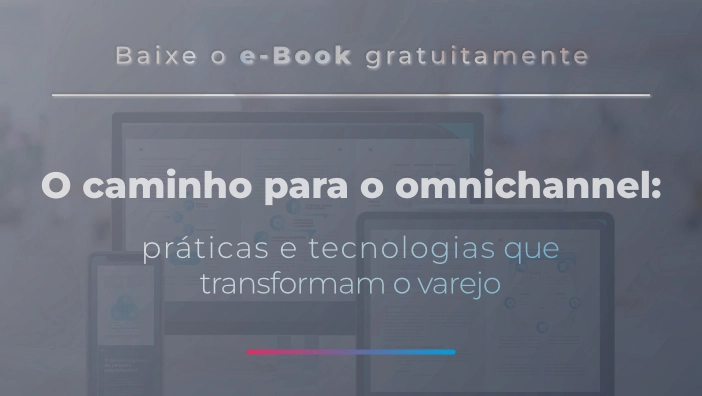 Uma imagem promocional (banner) com um fundo azulado e desfocado, onde se veem silhuetas de dispositivos eletrônicos (monitor, tablet e celular), aludindo a múltiplas plataformas. No centro, em texto branco sobreposto, lê-se no topo 'Baixe o e-Book gratuitamente', seguido por uma linha horizontal e o título em destaque 'O caminho para o omnichannel: práticas e tecnologias que transformam o varejo'. Na parte inferior, há um pequeno traço degradê do vermelho ao azul.