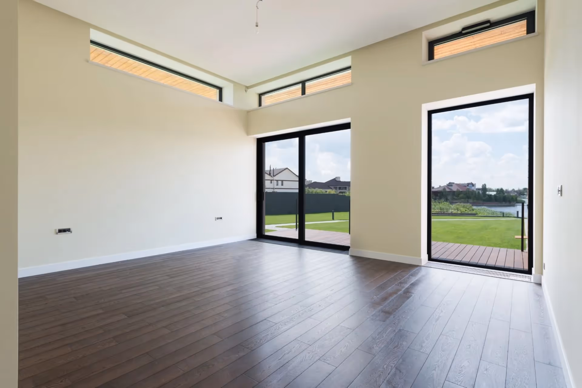  A spacious, empty living room with floor-length laminated windows 