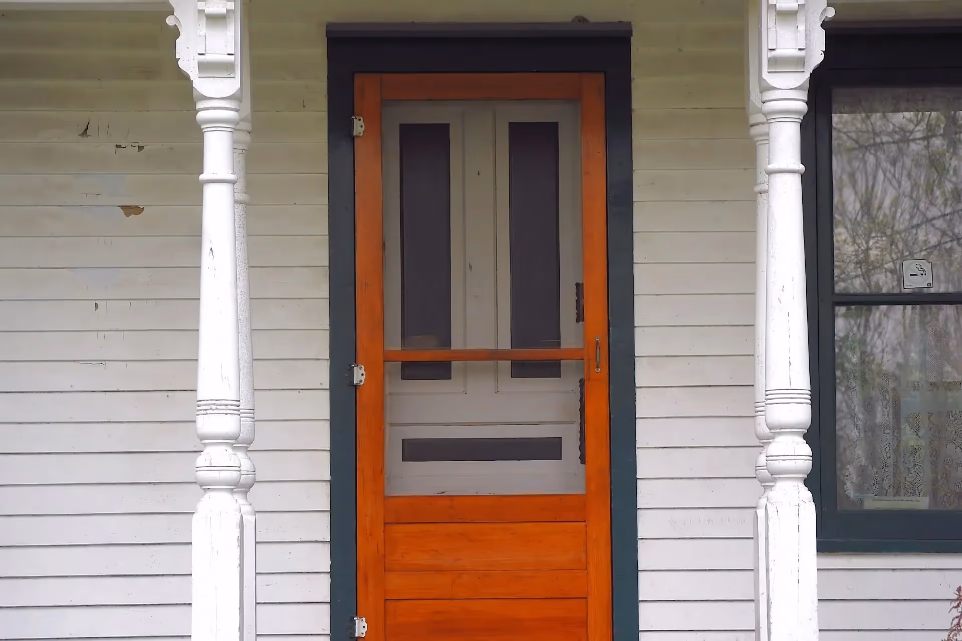 A wooden screen door protecting a front door