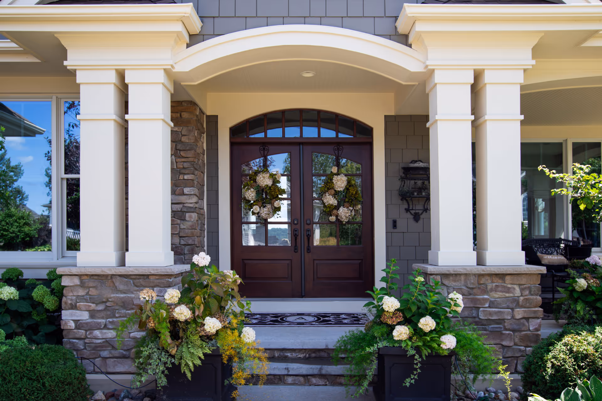 A home entryway, featuring custom French doors, composed of wood and glass.