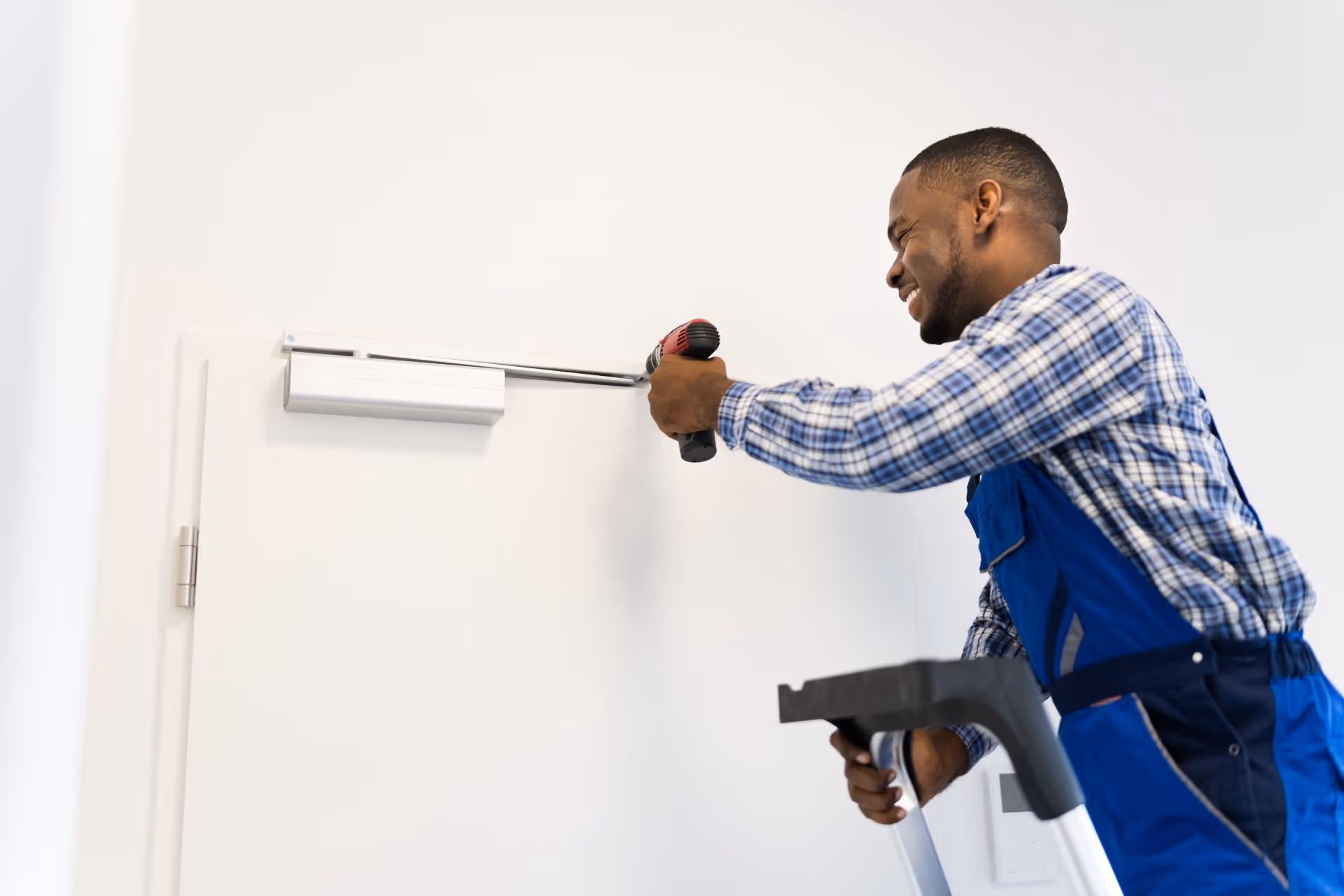  A person installing and adjusting a door closer on a commercial door