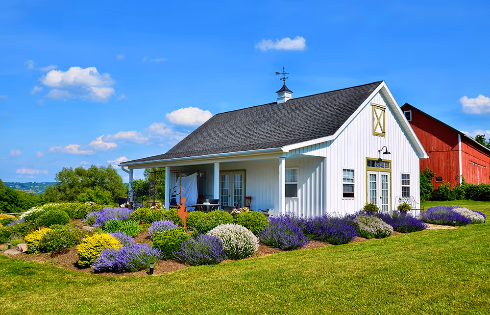 A barndominium house surrounded by a garden