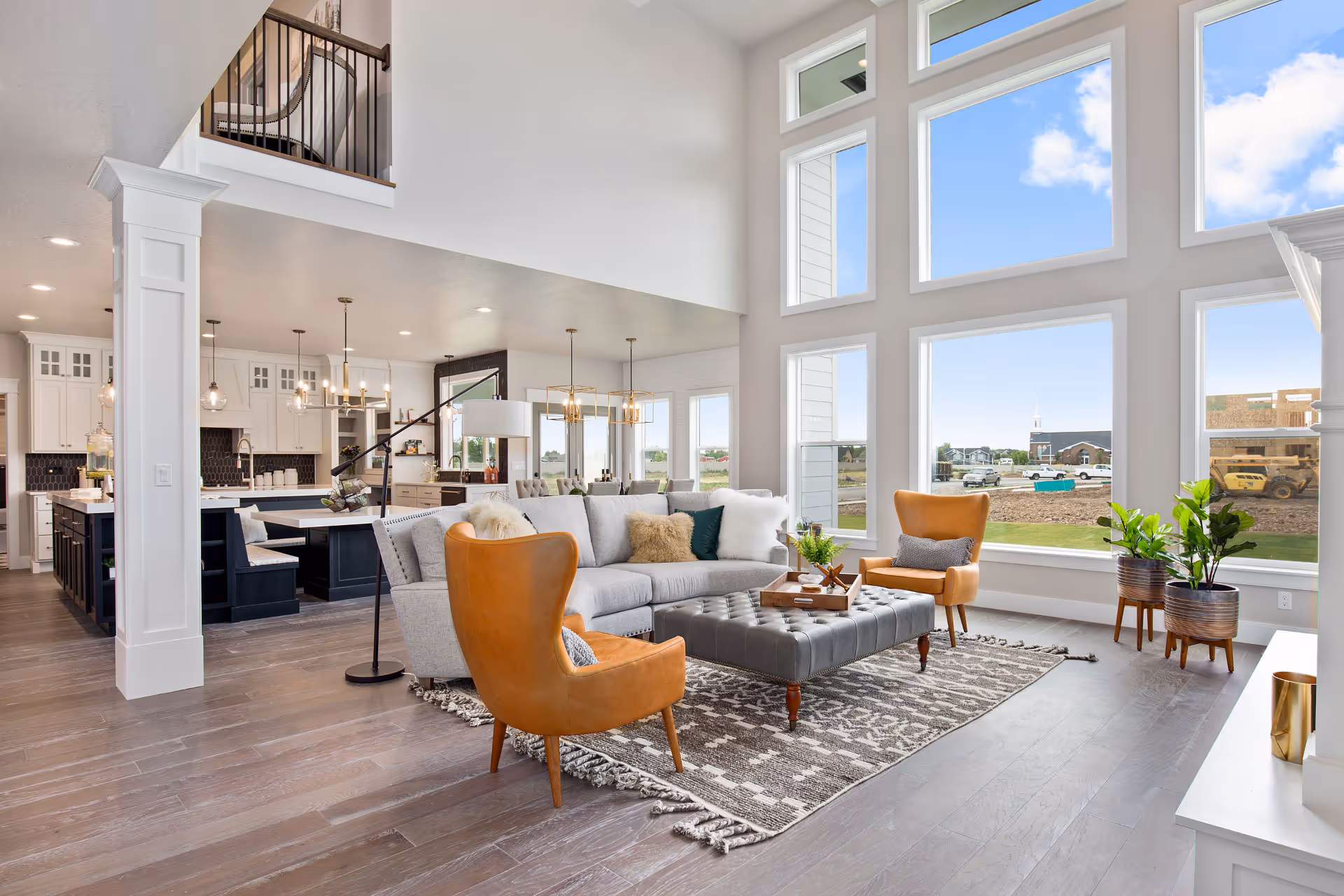 A living room with a window wall made of fixed picture windows extending up to the ceiling