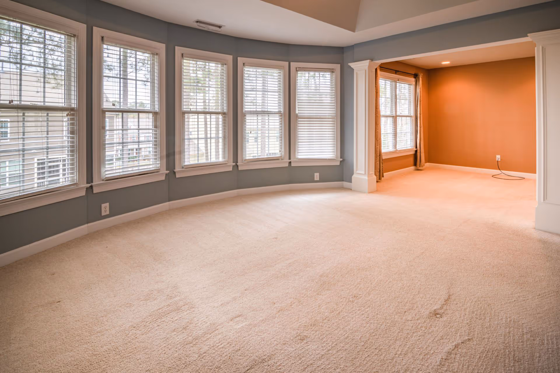 Interior with five double-hung windows covered by blinds