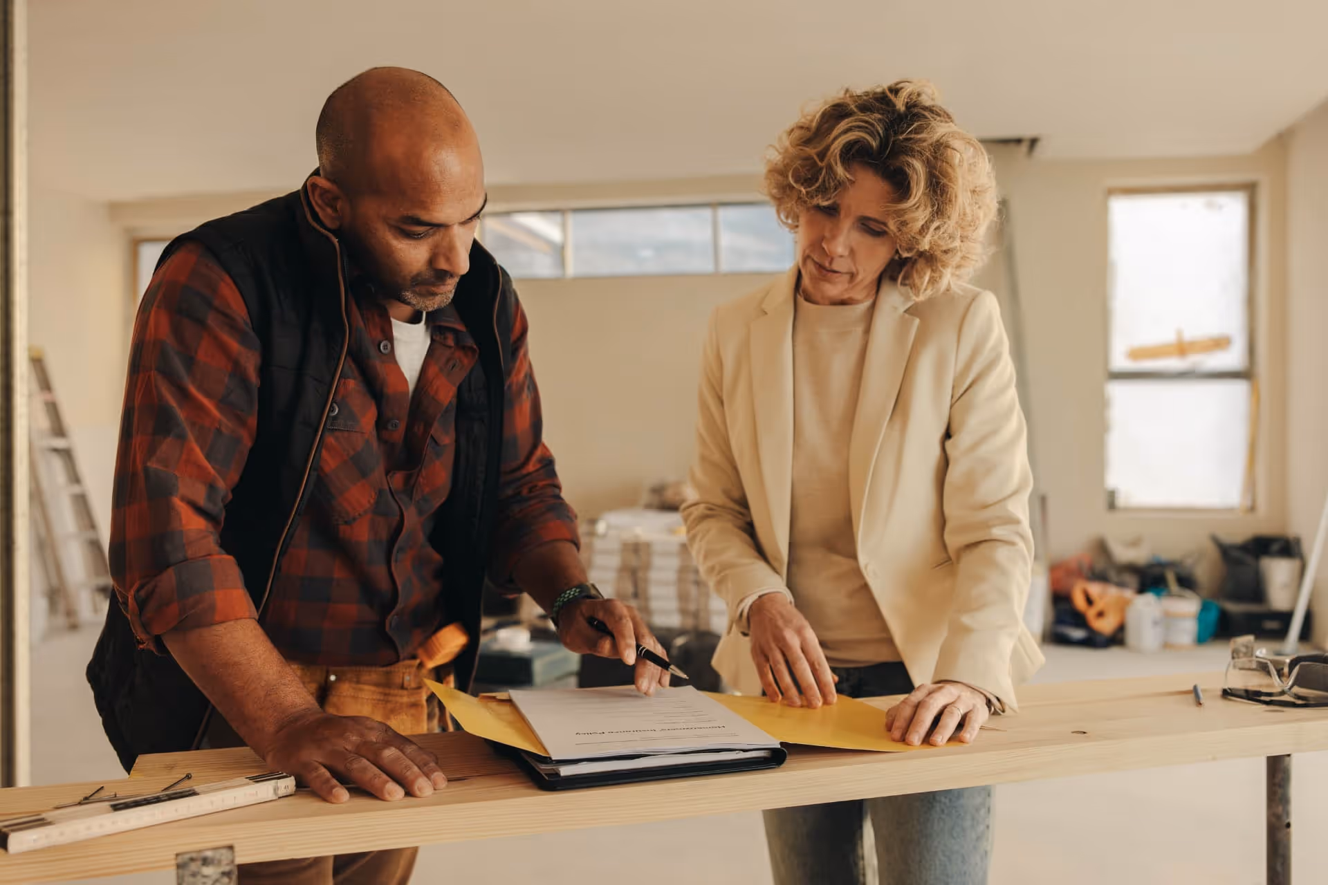contractor and homeowner signing a contract indoors for a home renovation project